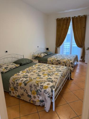 a bedroom with two beds and a tile floor at GENLIS Home in Cardito