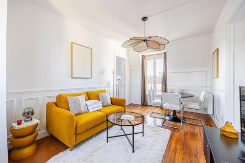 un salon avec un canapé jaune et une table dans l'établissement Apartment 1 Bedroom # Paris 14 # Alesia, à Paris