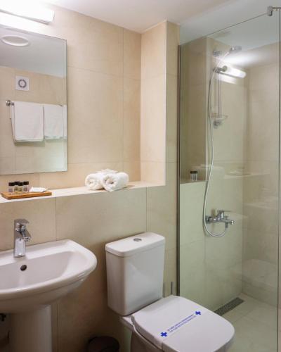 a bathroom with a toilet and a sink and a shower at Hotel Sileks in Ohrid
