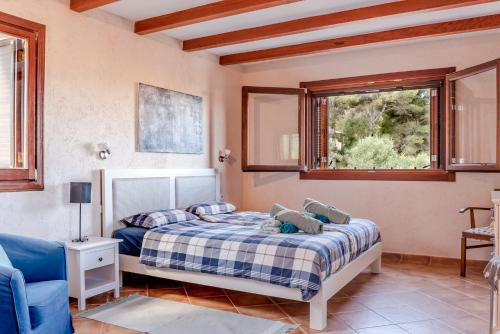 a bedroom with a bed and two windows at Finca Estrella in Artá