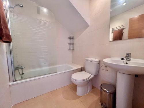 a white bathroom with a toilet and a sink at Condado de Alhama JARDIN 13 SV62 in El Romero