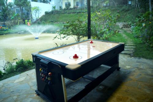 a ping pong table in front of a fountain at Timi Little Garden in Ba Vì