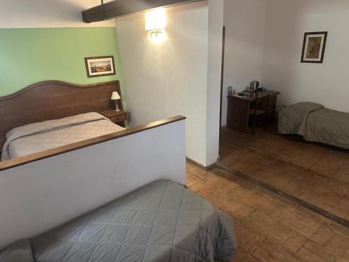 a bedroom with a bed and a desk in a room at Hotel Tenuta dell'Argento Resort in Civitavecchia
