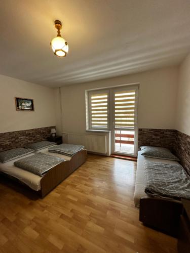 a bedroom with two beds and a window at Noclegi "Na Szczyrboku" Dom II in Korbielów