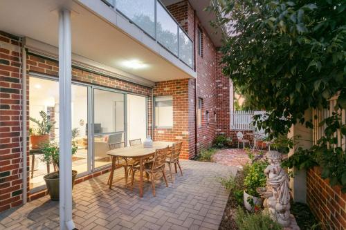 a patio with a table and chairs in front of a brick building at Terra de Sol A Mediterranean Escape in Perth in Perth