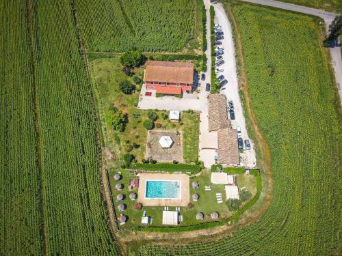 an aerial view of a field with a house and a pool at TORRE QUADRANA in Spello