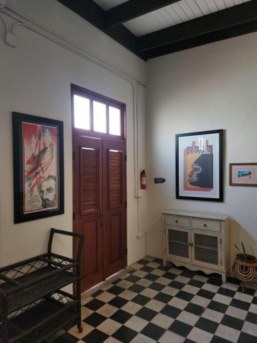a room with a door and a checkered floor at Casa 1921 in Manati