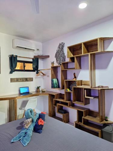 a room with a bed with a desk and shelves at Secret spot 3 in El Nido
