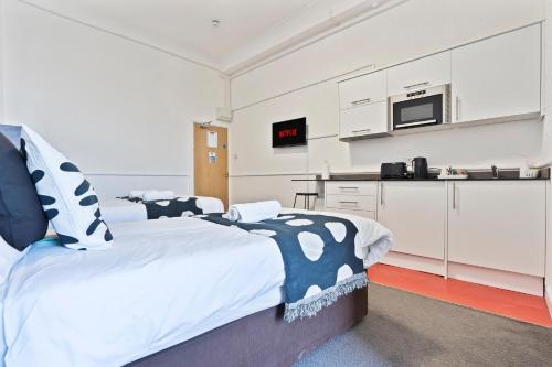 a bedroom with a large bed and a kitchen at Cosy hotel in Dudley in Dudley