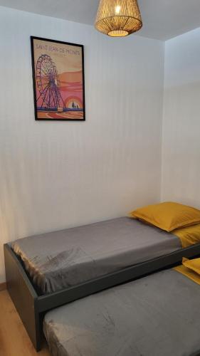 - un lit dans une chambre avec une photo sur le mur dans l'établissement Appartement de charme, face à l'ocean, à Saint-Jean-de-Monts