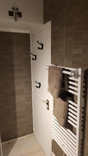 La salle de bains est pourvue d'une porte blanche et de serviettes. dans l'établissement Appartement de charme, face à l'ocean, à Saint-Jean-de-Monts