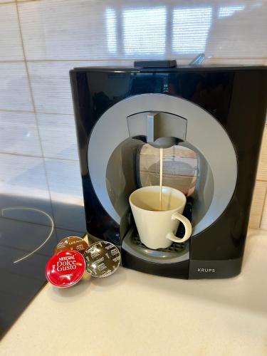 a coffee maker is making a cup of coffee at No̱410 City View Apartment & free parking in Krakow