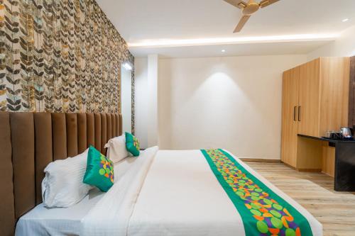 a bedroom with a large white bed with green pillows at Treebo Neel Orchid in Ujjain