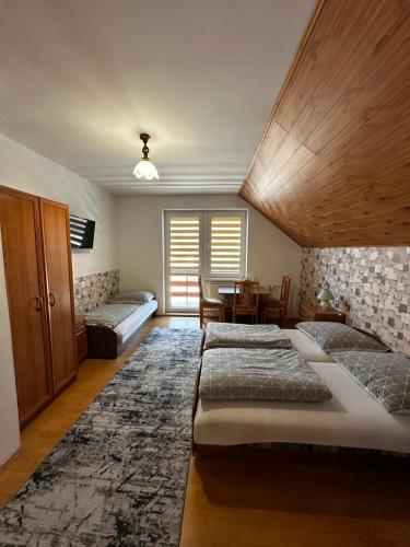a room with three beds and a table and a table at Noclegi "Na Szczyrboku" Dom II in Korbielów
