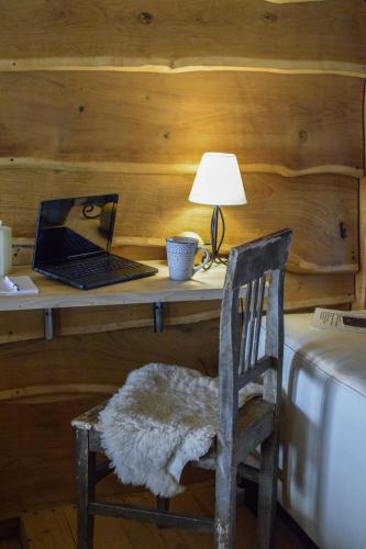 a desk with a laptop and a chair with a lamp at Zonamita house in Velika Remeta