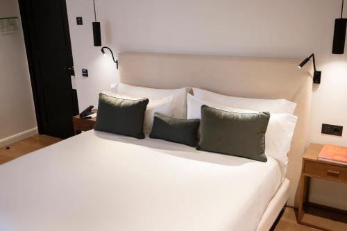 a bedroom with a white bed with two pillows at Hotel Boutique Sidonia in Jerez de la Frontera