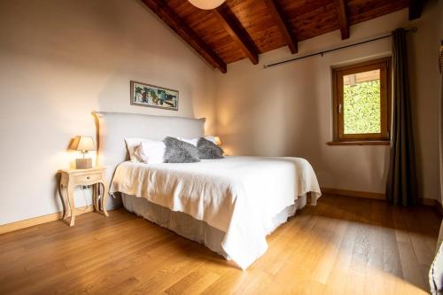 une chambre avec un lit blanc et une fenêtre dans l'établissement Villa Petrarca, Luxury villa with spectacular views on lake Orta, à Pella