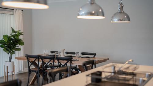 a dining room with a wooden table and chairs at 35 Hamptons Luxury Escape Family Home Sleeps9 in Baldivis