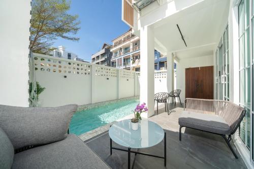 a patio with a couch and a table and a pool at Patong private pool Villa 5BR 4Bath By MP property in Patong Beach