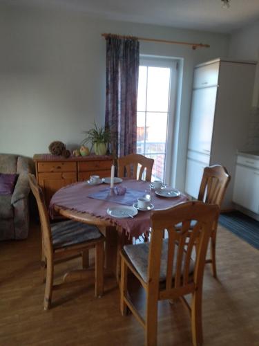 a dining room table and chairs in a living room at Ferienhof Alte Schmiede in Burgpreppach