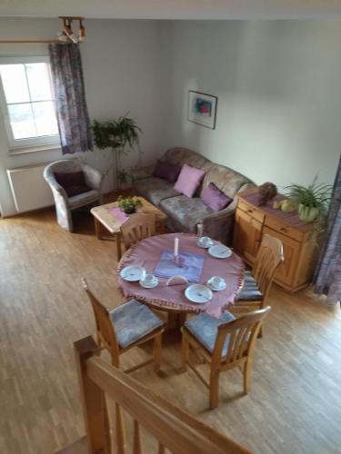 a living room with a table and a couch at Ferienhof Alte Schmiede in Burgpreppach