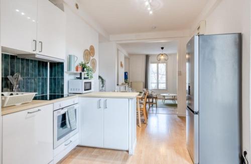  La cuisine est équipée de placards blancs et d'un réfrigérateur. dans l'établissement Amiral, au Havre