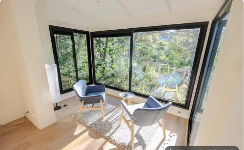 a living room with two chairs and a large window at Le Dandy in Aix-en-Provence