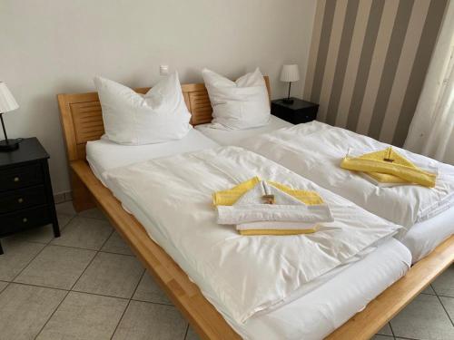two beds with white sheets and yellow towels on them at Ruhe auf Borkum in Borkum