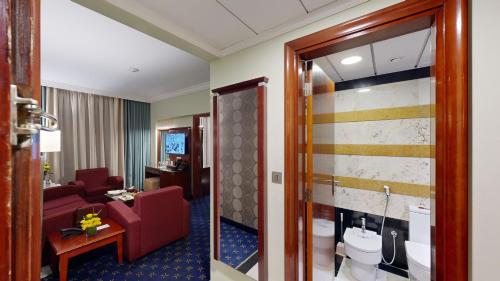 a hotel room with a red couch and a bathroom at Al Muna Kareem Hotel- EX LEADER in Al Madinah