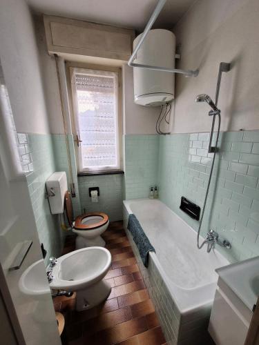 a bathroom with a toilet and a tub and a sink at Il Posticino Della Valsassina in Casargo