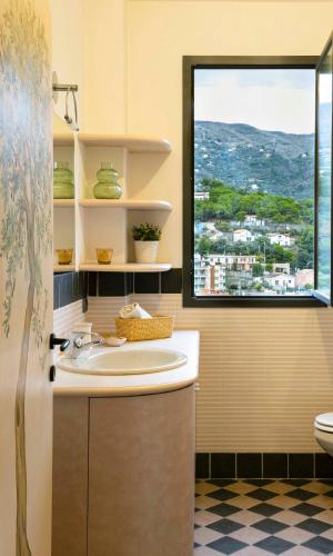 a bathroom with a sink and a window at Casa Armonia by Vayadù in Alassio