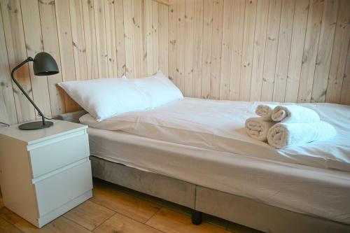 a bedroom with a bed with towels on it at Kintų Perlas Vila dviems II in Kintai