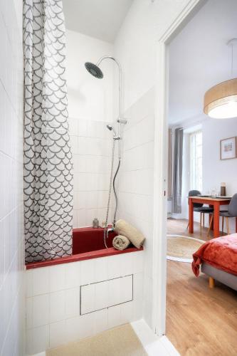 - une salle de bains avec douche dans l'angle de la chambre dans l'établissement Studio Ambre, à Rennes