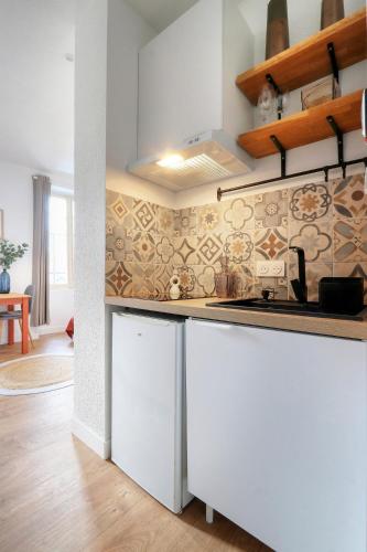 - une cuisine avec un îlot blanc dans une chambre dans l'établissement Studio Ambre, à Rennes