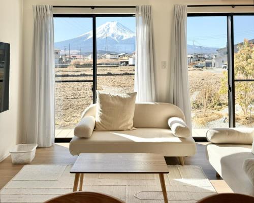 a living room with a couch and a mountain view at 富士の宿燦々 in Fujiyoshida