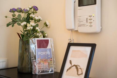 a vase of flowers and a picture on a table at GuestReady - Pleasant Hideway in Porto in Porto