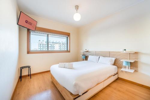 a bedroom with a large white bed and a window at GuestReady - Pleasant Hideway in Porto in Porto