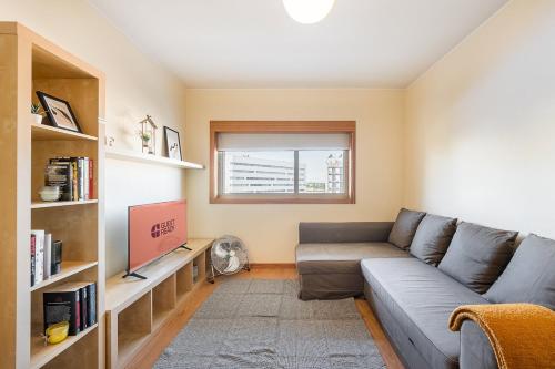 a living room with a couch and a tv at GuestReady - Pleasant Hideway in Porto in Porto