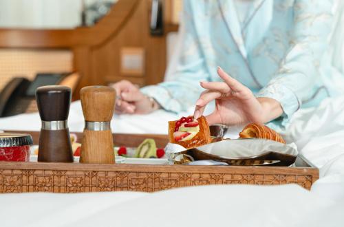a person sitting at a table with a tray of food at The Chedi Katara Hotel & Resort in Doha