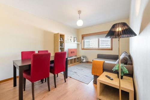 a living room with a table and red chairs at GuestReady - Pleasant Hideway in Porto in Porto