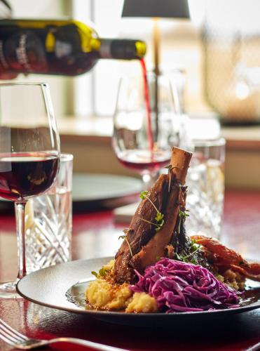 a plate of food on a table with a glass of wine at Midgard Base Camp in Hvolsvöllur