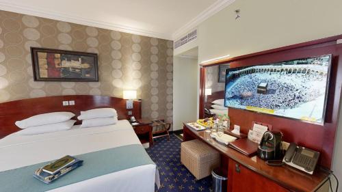 a hotel room with a bed and a flat screen tv at Al Muna Kareem Hotel- EX LEADER in Al Madinah