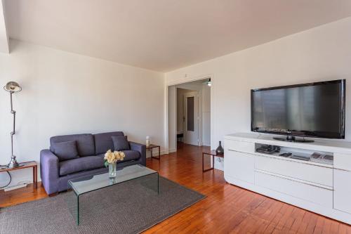 un salon avec un canapé et une télévision à écran plat dans l'établissement Appartement Ixelle - Welkeys, à Biarritz