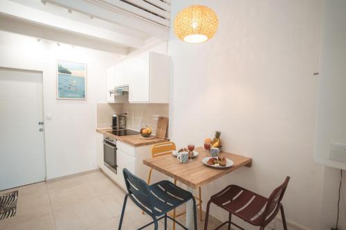 a kitchen with a table and chairs in a room at L'Ayapana, appart de charme tout proche du Lagon in Filaos