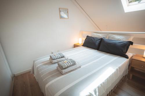 a bedroom with a large bed with two pillows on it at L'Ayapana, appart de charme tout proche du Lagon in Filaos