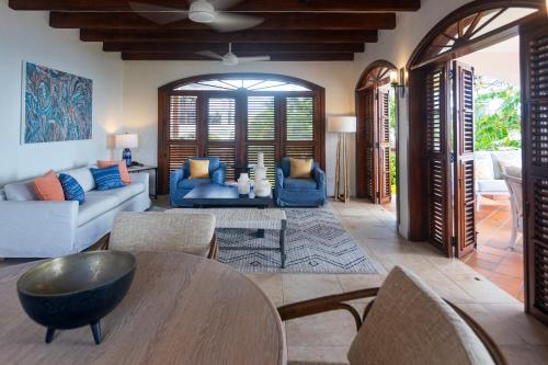 a living room with a couch and a table and chairs at Cap Maison Resort & Spa in Cap Estate