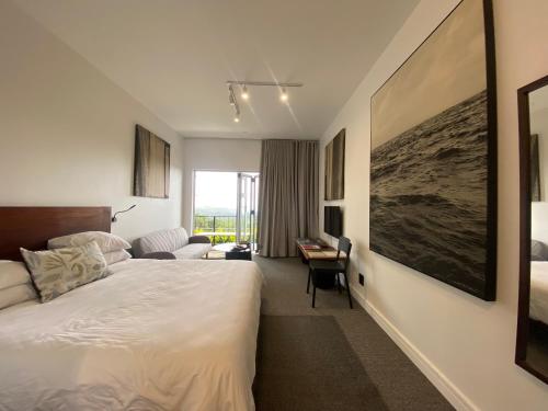 a hotel room with a bed and a desk at Bloom Homestead Apartment, Summerveld in Hillcrest