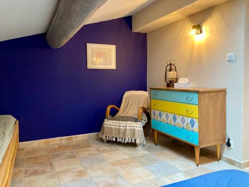 - une chambre avec un mur bleu et une commode dans l'établissement La Suite, à Mollégès