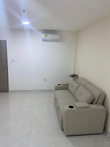 a living room with a couch in a white room at Hotel Tepia in Maicao