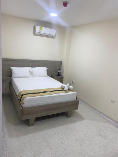 a bedroom with a bed in a white room at Hotel Tepia in Maicao